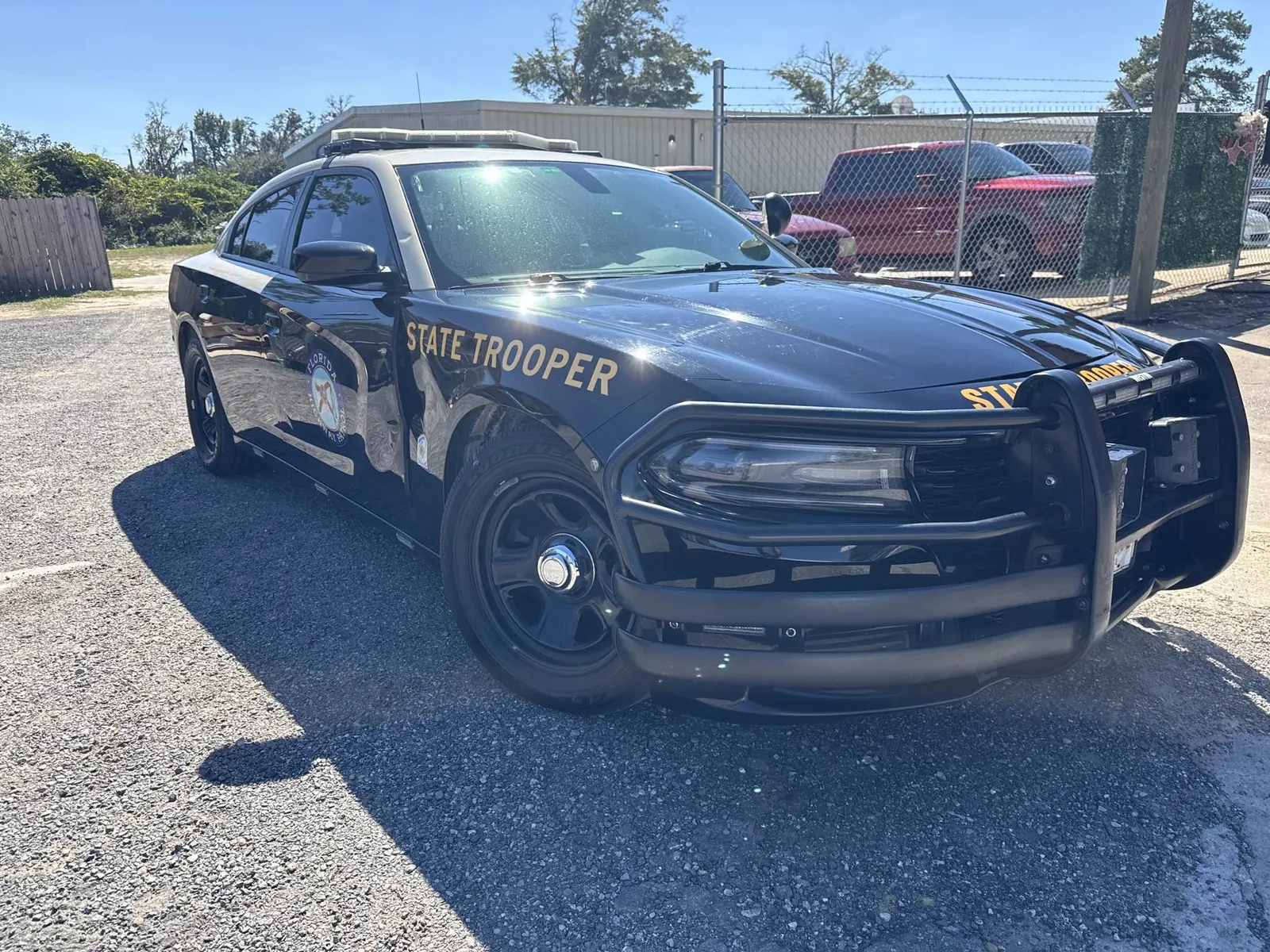 Driver-side front fender and door damage on a 2021 Florida Highway Patrol Dodge Charger before repair